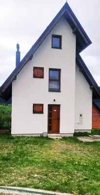 a white house with a brown door at Connect 4 - Vlašić Vikendica in Šišava