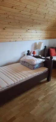 a bed in a room with a wooden wall at Connect 4 - Vlašić Vikendica in Šišava