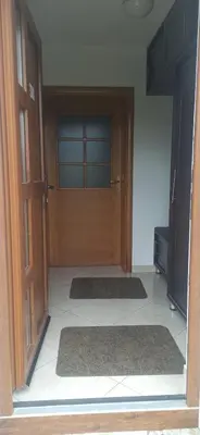 a room with a wooden door and two rugs on the floor at Connect 4 - Vlašić Vikendica in Šišava