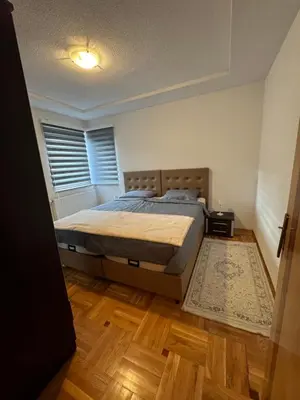 a bedroom with a bed and a window and a rug at Golden Lilly Apartment in Bihać