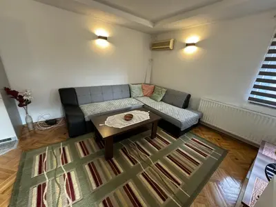 a living room with a couch and a coffee table at Golden Lilly Apartment in Bihać