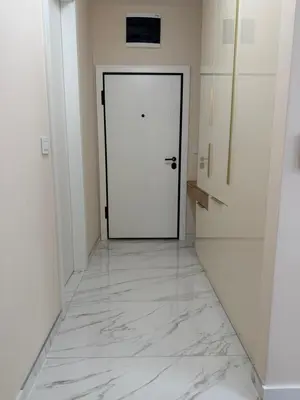 a hallway with a white door and a marble floor at Palata Royal Banja Luka Luxury Apartment in Banja Luka