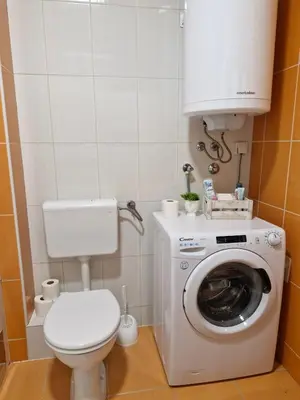 a bathroom with a toilet and a washing machine at Pollaris in Banja Luka