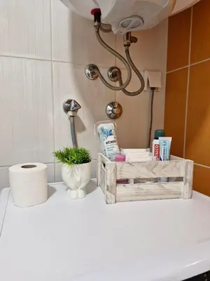 a bathroom counter with a wooden box with products on it at Pollaris in Banja Luka