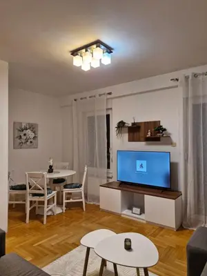 a living room with a large television and a table at Pollaris in Banja Luka