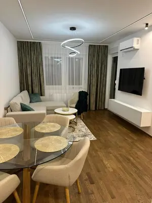 a living room with a couch and a table and chairs at Aurelia Apartmani - Banja Luka-Borik in Banja Luka