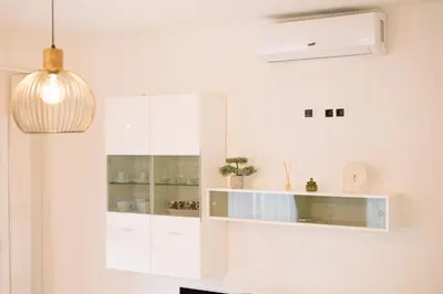 a kitchen with white cabinets and a potted plant at Studio apartman NINA in Livno