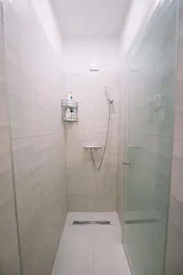 a shower with a glass door in a bathroom at Studio apartman NINA in Livno