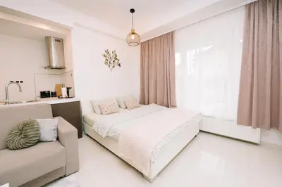 a bedroom with a bed and a couch and a window at Studio apartman NINA in Livno
