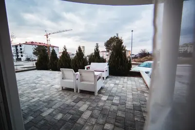 two white chairs sitting on a brick patio at Studio apartman NINA in Livno