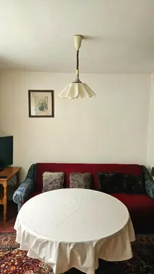 a living room with a red couch and a white table at Stan na dan - Apartman Centar Kakanj in Kakanj