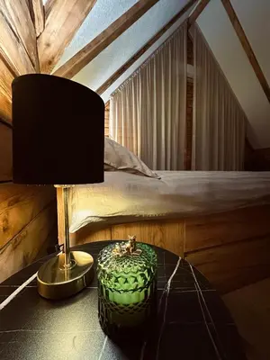 a bedroom with a bed and a table with a lamp at Green District - Riverside Luxury Lodge in Banja Luka