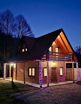 a log cabin with christmas lights on it at Green District - Riverside Luxury Lodge in Banja Luka