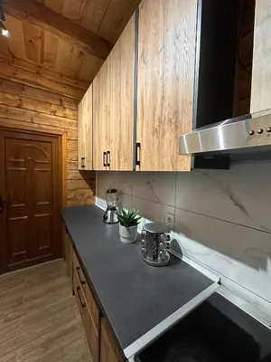 a kitchen with wooden cabinets and a counter top at Green District - Riverside Luxury Lodge in Banja Luka
