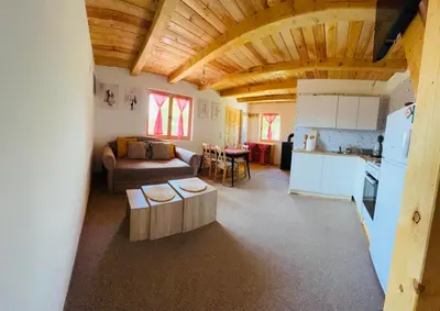 a living room with a couch and a table and a kitchen at Brvnara Duga njiva Banjaluka in Čelinac