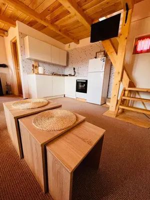 a living room with two tables and a kitchen at Brvnara Duga njiva Banjaluka in Čelinac