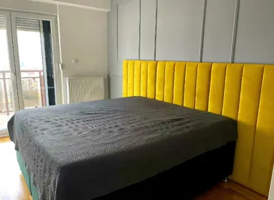 a bedroom with a bed with a yellow headboard at Panorama in Pištelići