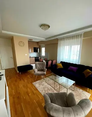 a living room with a couch and chairs and a kitchen at Panorama in Pištelići