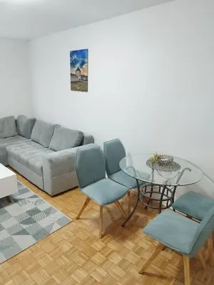 a living room with a couch and a glass table at Apartman Harmony N&D in Starčevica