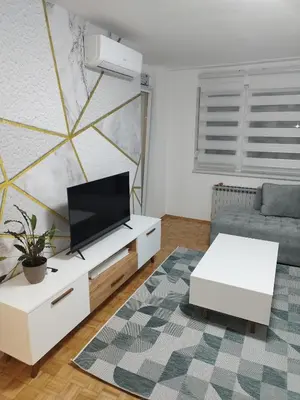 a living room with a couch and a tv at Apartman Harmony N&D in Starčevica