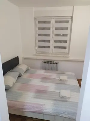 a bedroom with a large bed with two pillows at Apartman Harmony N&D in Starčevica
