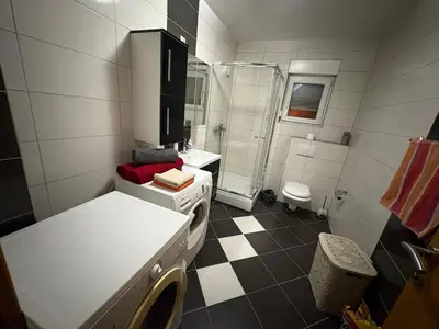 a bathroom with a shower and a sink and a toilet at Sobe DANA in Teslić