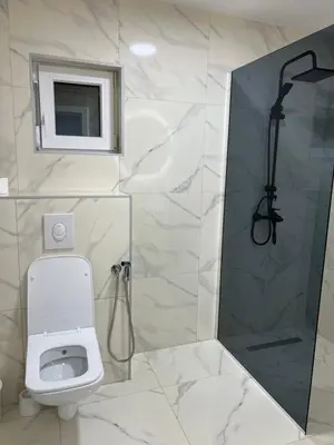 a white bathroom with a shower and a toilet at Villa Sunčani Raj in Gradačac