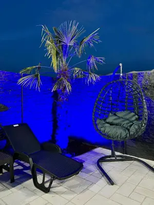 a chair sitting on a patio with a blue background at Villa Sunčani Raj in Gradačac