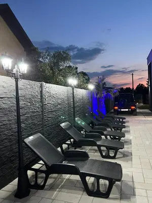 a row of benches sitting next to a wall with lights at Villa Sunčani Raj in Gradačac
