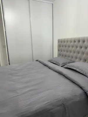 a bedroom with a large bed with a gray blanket at Apartman welsh in Bugojno