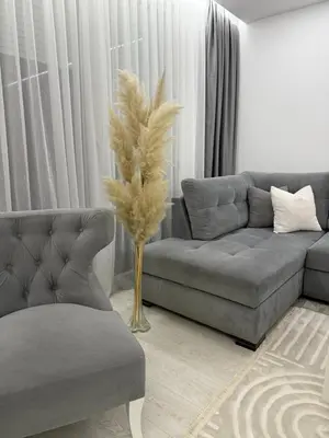 a living room with a couch and a vase with feathers at Apartman welsh in Bugojno