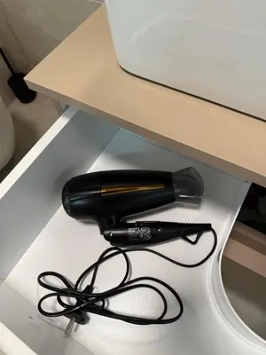 a black hairdryer sitting on top of a desk at Apartman welsh in Bugojno