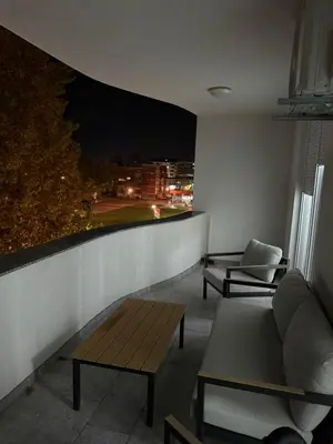a room with two chairs and a couch on a balcony at night at Apartman welsh in Bugojno