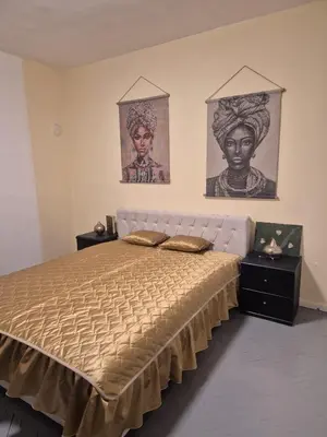 a bedroom with a large bed with two pictures on the wall at Apartman Una Vista in Ivišovo Greblje