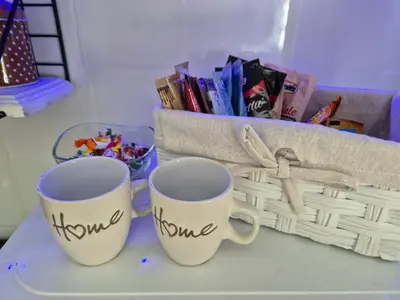 two coffee mugs with the word home next to a basket at Apartman Una Vista in Ivišovo Greblje