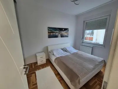 a small bedroom with a bed and a window at Urban BL in Banja Luka
