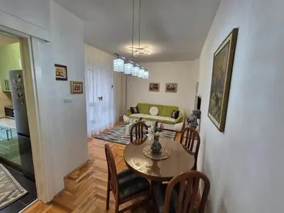 a dining room and living room with a table and chairs at Urban BL in Banja Luka