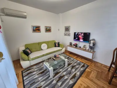 a living room with a green couch and a tv at Urban BL in Banja Luka