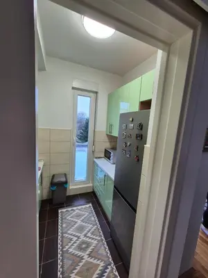 a kitchen with green cabinets and a stainless steel refrigerator at Urban BL in Banja Luka