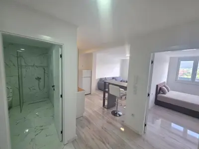 a room with a bathroom with a shower and a bedroom at Dora in Bugojno