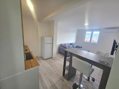a room with a desk and a kitchen with a couch at Dora in Bugojno