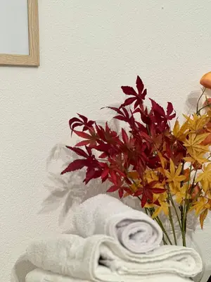 a vase of flowers sitting next to a towel at Apartment DUNJA 2 Laktasi in Laktaši