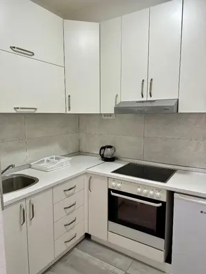 a kitchen with white cabinets and a sink and a stove at Apartment DUNJA 2 Laktasi in Laktaši