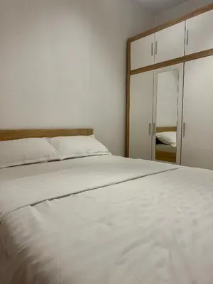 a bedroom with a white bed and a mirror at Apartment DUNJA 2 Laktasi in Laktaši