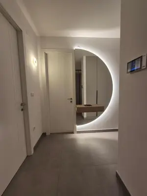 an empty hallway with a round mirror in a room at Palace Residence Apartment in Banja Luka