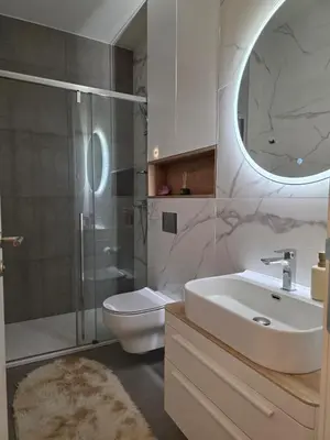 a bathroom with a sink and a toilet and a mirror at Palace Residence Apartment in Banja Luka