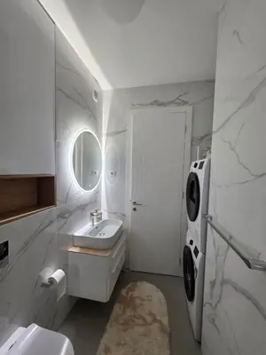 a white bathroom with a sink and a mirror at Palace Residence Apartment in Banja Luka