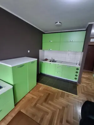 a kitchen with green cabinets and a sink at Studio apartman in Banja Luka