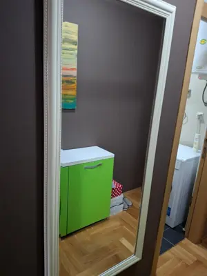 a bathroom with a green cabinet and a mirror at Studio apartman in Banja Luka
