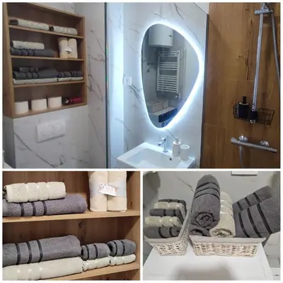 a bathroom with a mirror over a sink and towels at GOLD Apartmani Banja Luka in Banja Luka